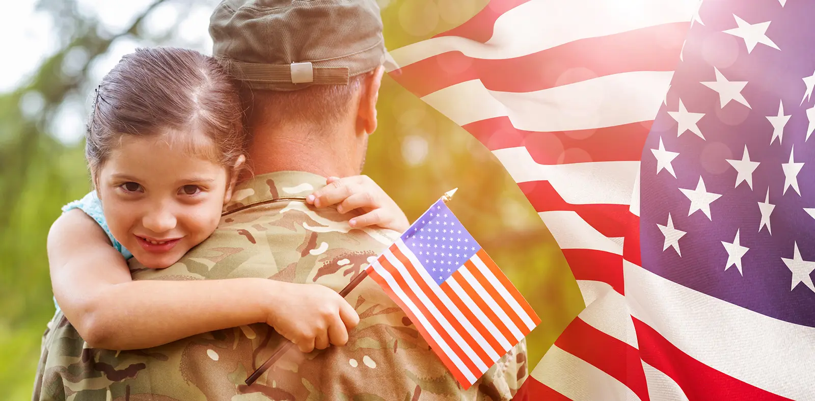 Soldier hugging daughter holding American flag