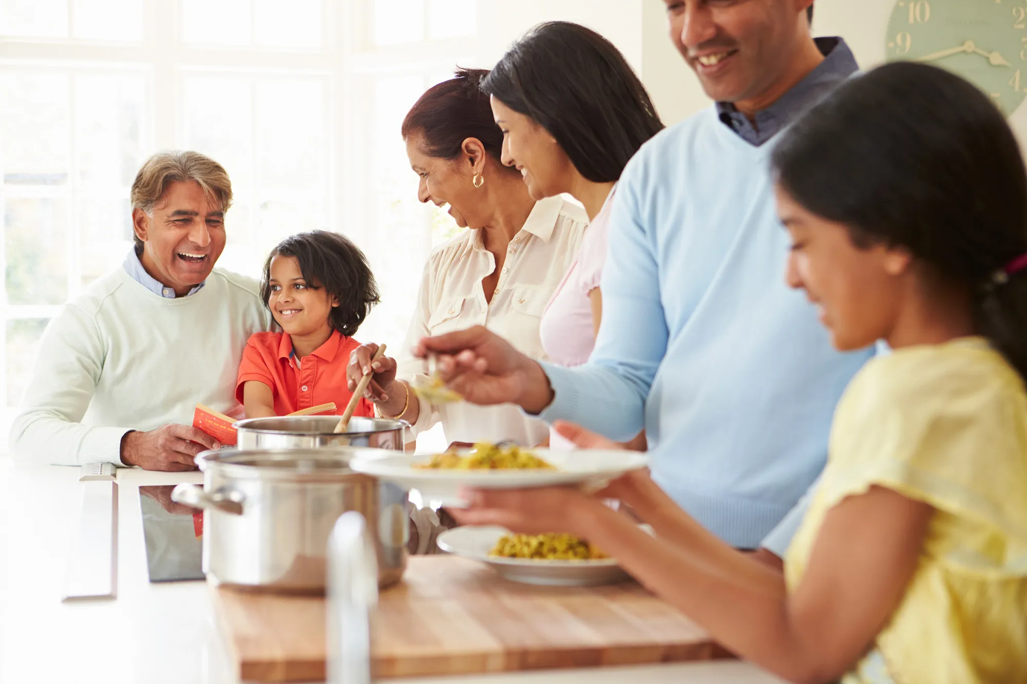 Family cooking and eating together in kitchen