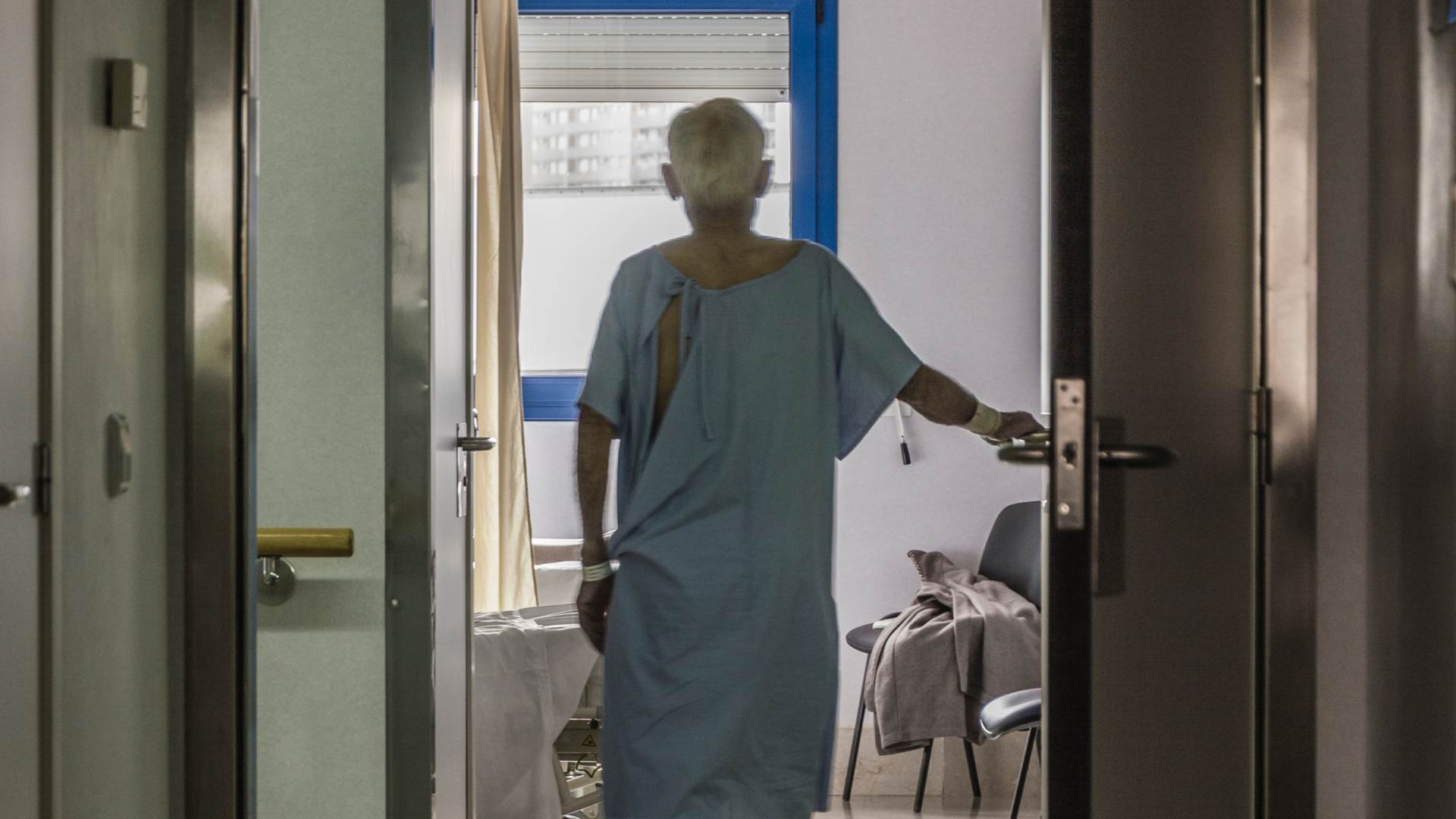 Patient in hospital gown standing by window thinking about medicaid protection in laurel county