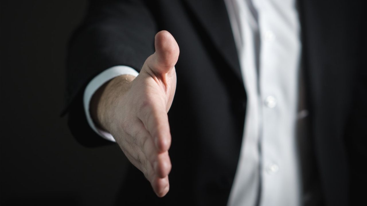 Medicaid planning lawyer extending hand for a handshake